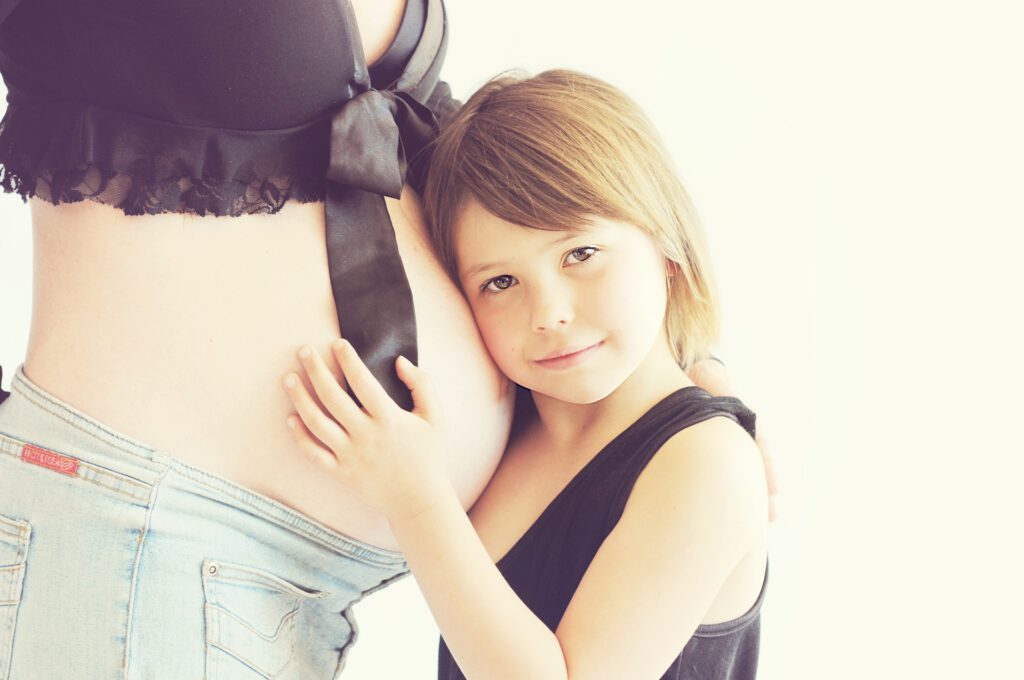เด็กผู้หญิงลูบท้องแม่